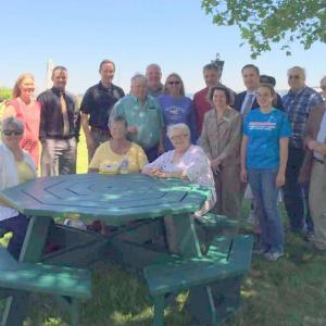 Volunteers and business associates gather with Rockland City Councilor Louise MacLellan-Ruf (standing, purple shirt) and Rockland City Manager James Chaousis (standing, fourth from right) for a group photo.