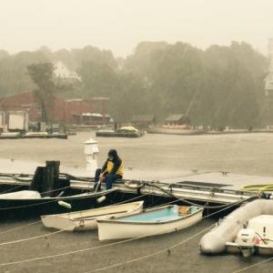 Boats are being baled nonstop as more than five inches of rain fell earlier on Sept. 30 in the Midcoast. In Rockport Harbor, assistant harbor master Eliza Massey has been pumping a series of dinghies at the dock. (Photo by Lynda Clancy)