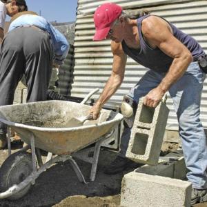 Patrick Manley, at the wheelbarrow, in Guatemala, working with volunteers to build cookstoves. (Photo courtesy Patrick Manley)
