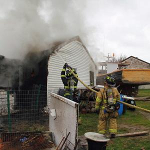 Firefighters work at a Bayside West home in Owls Head Tuesday morning to put out a fire that started in a chicken coop, where a heat lamp was warming four new baby chickens. (Courtesy Rockland Fire Department/by Alan Athearn)