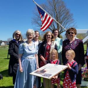 Suzy Shaub (in blue dress) stands with members of the Lady Knox Chapter, DAR, near the new sign for the Revere bell on the grounds of the Knox Museum. The sign is dedicated in Shaub’s honor. (Photo by Sarah Shepherd)