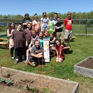 Thomaston Grammar School Students display the new weed whacker they received to replace the one that was stolen.