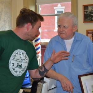Rockport Select Board member Owen Casas shares a joke with Roger Jones, June 7, at the Jones Brothers barber shop. (Photo by Lynda Clancy)