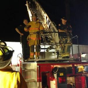 Participants in the inaugural class of the Citizens Public Safety Academy experienced what it was like to climb a 105 foot aerial ladder at night during their first session with the Camden Fire Department. Left to right, Kevin Mulvihill, firefighter, David Heath, student, and Todd Anderson, firefighter. (Photo by Chris Farley)