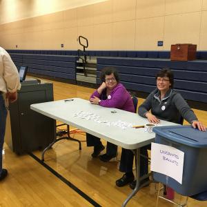 From left, ballot clerks Peggy Rice and Vicki Eugley work the late shift Tuesday evening in Lincolnville, where the Maine Secretary of State’s Office approved using a blue tote as an alternative to collect ballots and speed voting, according to Lincolnville Deputy Warden Karen Secotte. (Photo by Holly S. Edwards)