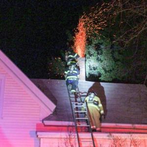 Sparks fly out from the top of a chimney at a home on Suffolk Street in Rockland Saturday night. (Courtesy Rockland Fire Department/by Alan Athean)