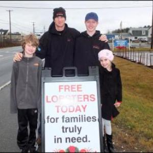 Left to right Nadia Cook-Ames, Noah Ames, Jack Wadsworth and Noah Ames Jr. as they set up and get ready to start handing out lobsters in Thomaston on Christmas Eve.