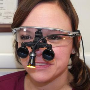Dental Hygienist Alison Gaeth displays the loupe light purchased from a recent donation by the Camden Rotary to Knox County Dental Clinic.