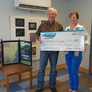Alvin Chase, Jr. of Eastern Tire and Auto Service in Rockland, presents a sponsorship check to Mary Bumiller, Board member of Georges River Land Trust.