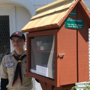 Zachary Dorr, 16, and one of three Little Free Pantries that he conceived and installed as part of the service required to earn his Eagle Scout Badge. The pantry pictured is located at the First Congregational Church in Camden, the same church that sponsors Boy Scout Troop 200. (Photo: Jenna Lookner)