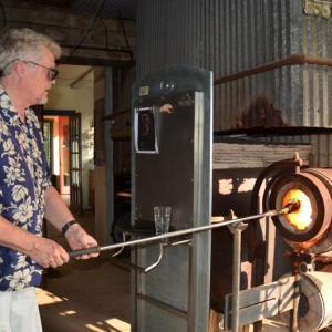 Richard Remsen works with the molten glass as it takes shape in the 2,100-degree oven at the Glass Foundry in West Rockport. (Photo by Lynda Clancy)