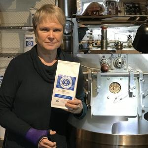 Susanne Ward in front of the coffee roaster at Rock City Roasters.