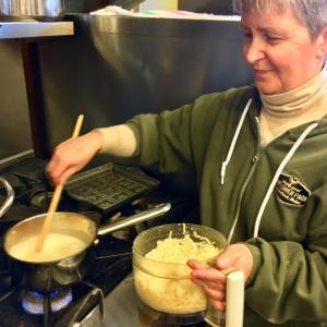 Kim Martin works her magic over a pot of cheese fondue in the kitchen at Eventide. SUZI THAYER/Boothbay Register