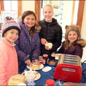 Jenna Yarosis, Fiona Farmer, Miranda Yarosis and Sadie Farmer all contemplate their topping for their toast at the Rockport Library