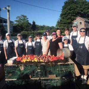 Merritt Carey (front row, third from right) and her serving staff prepare to serve “Fisherman’s Feed” buffet to SGBA members and guests at Luke’s of Tenants Harbor on Tuesday evening, June 19. (Photo courtesy of the St. George Business Alliance)