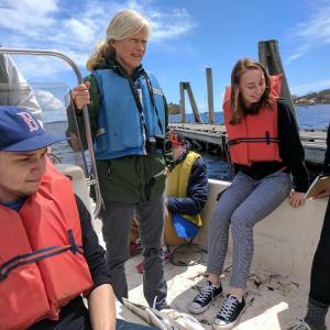 Watershed teacher Janet McMahon and climate change students survey water levels in Camden Harbor. (Photo courtesy of Watershed)