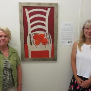 Sherry Reimer, Housing Coordinator , MCH, Inc. and Annette Naegel, Director of Conservation, Georges River Land Trust with oil painting by Bernard Langlais. (Photo courtesy of GRLT)