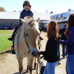 A young rider is delighted to begin his ride on this beautiful pony at SeaHorse Stables’ open farm day Oct. 14. (photo by Erica Thoms)