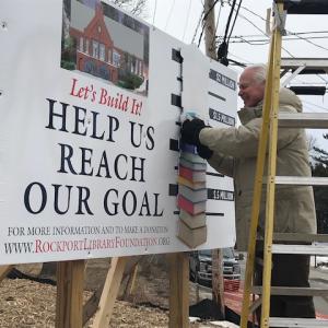 Rockport Library Foundation Vice President John Viehman peels off another milestone for the library capital campaign. With a recent $150,000 donation from the Rockport Library Committee, the Foundation has collected $1.45 million toward its $2 million goal. (Photo courtesy Rockport Library Foundation)