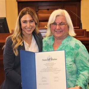Senator Herbig, left, presents Pat Clark with a legislative sentiment in the Senate Chamber. (Photo courtesy Senator Herbig’s office)