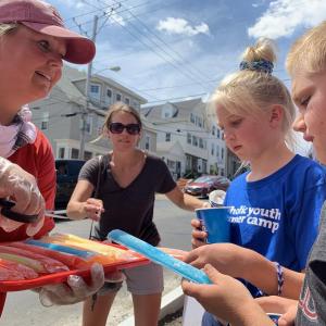 Casey Colby of Wiscasset’s Red’s Eats offers pops to Granville, Ohio siblings Annabelle Bergeron, 10, and A.J. Bergeron, 9, as their family waited in line Saturday afternoon, July 20. SUSAN JOHNS/Wiscasset Newspaper
