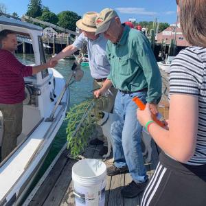 Junior Kaylee Ames greeted each boat with a knife during the Sunday’s ceremony at the Brown’s Boatyard dock on North Haven.(Photo by Ashlynn Ames)