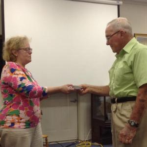 Ann Smith, treasurer of the Wessaweskeag Historical Society, hands the donation to Peter Markoon of the People’s United Methodist Church. (Photo courtesy Wessaweskeag Historical Society)