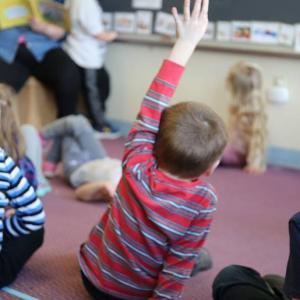 Child at WCAP pre-K collaboration site raises his hand to answer a question asked by his teacher. (Photo courtesy Waldo Community Action Partners)