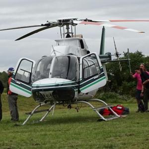 Maine Forest Service’s Chief Pilot John Crowley (far left) stands next to one of the Service’s helicopters. (photo by Erica Thoms)