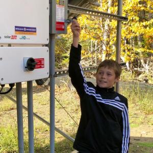 Islesboro Central School fifth grade student Jaykob Zolllman flips the switch at a ceremony Oct. 9. (Courtesy Charles Hamm)
