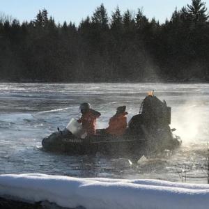 Game Warden Sergeant Ron Dunham maneuvers a hovercraft over the thin ice and towards shore after rescuing a stranded hunter on the river (Photo Courtesy of the Maine Department of Inland Fisheries and Wildlife).