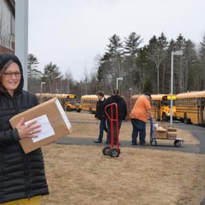 Camden Hills Regional High School librarian Beth Chamberlin delivers a box of poetry books to a waiting bus to be delivered to a sophomore who asked if they could be sent to her. (Photo by Lynda Clancy)