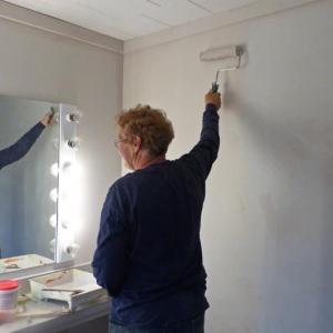 Painting dressing room (volunteer Bridget Hooper). (Photo courtesy of Waldo Theatre)