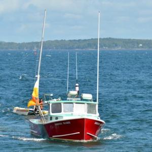 Nick Heal, captain of the Kristin Marie, along with crew members Alex Bryant and Jared Gilbert tow the disabled catamaran and sailor Brendan Browne back to the Lincolnville Harbor dock, beside the ferry landing at Lincolnville Beach. (Photo by Lynda Clancy)