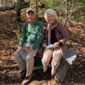 McAllister sits with his wife, Ursula, on his newly installed recognition bench at the Ducktrap Preserve. (Photo courtesy Coastal Mountains Land Trust)