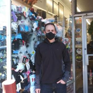 Colburn Shoe Store owner Colby Horne stands next to his window filled with socks. (photo by Erica Thoms)