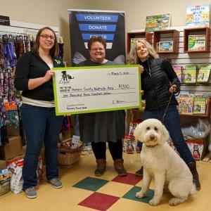 L to R: Chelsie Herrin (marketing manager for the Loyal Biscuit) presents a Fenway Fund grant check to Lisa Oakes (Humane Society Waterville Area executive director) and Dianna Demers (HSWA Board of Directors secretary) with her rescue dog, Sadie the Doodle. (Photo courtesy Loyal Biscuit)