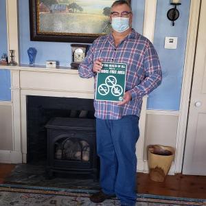 Gary Born, innkeeper at Elms of Camden, holds a Tobacco-Free sign. (Photo courtesy Knox County Community Health Coalition)