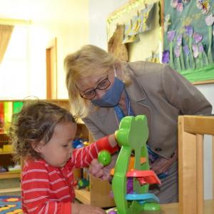 Maine Gov. Janet Mills explores with a pre-schooler one of the educational toys at the Penobscot Bay Area YMCA on May 25. She visited with babies and children before laying out the specifics of the child care investment plan. (Photo by Lynda Clancy)