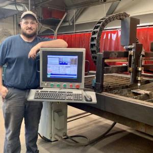 Waldo County Technical Center's Welding Trades Instructor Kevin McKenney stands next to the CNC plasma table donated to the program by University of Maine at Orono. (Photo courtesy Waldo County Technical Center)