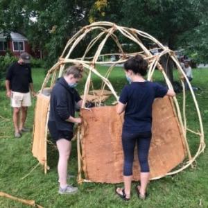 Under the supervision of Penobscot artist Barry Dana, students Maddie Thorndike, left, and Carly McCabe built a wigwam on the west lawn of the Skowhegan History House (SHH) campus last summer. The wigwam construction was the first phase of a two-year exhibit, “Wabanaki Voices: Connecting Past, Present, Future,” organized by the SHH with support from a Maine Expansion Arts Fund grant. (Photo by Susan Cochran)