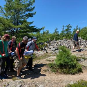 Volunteers from Camden Fire Dept., Camden Hills State Park rangers, Coastal Mountain rescue and North East Mobile Health Services help carry a man up the steep Mount Battie Trail in a Stokes basket after he suffered an ankle injury July 24, approximately half way down the face of Mount Battie. (Photo courtesy Camden Fire Dept.)