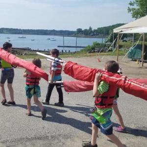 Day one of Sail Kids for Free (SKFF) program: carrying sails and learning to rig the Optimist sailing dinghies. (Photo Sail Power & Steam Museum, Rockland)