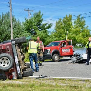 A Camden crash at the intersection of Mechanic Street, where it turns into Hosmer Pond Road, and Melvin Heights Road sent one vehicle onto its side just before noon, Aug. 3. Steve Laite, owner of Camden Exxon, with Camden Firefighter Clint Beveridge and Camden Police Officer Brook Hartshorn tend to scene. (Photos by Lynda Clancy)