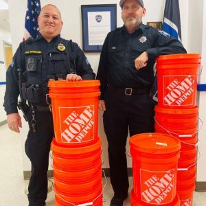 Rockland Police Department officers stand with sand buckets ready to be distributed to senior residents. (Photo courtesy Rockland Police Department Facebook)