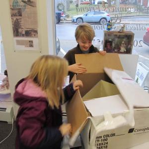 Avonlea Lecher, 10 and her brother Cole Lecher, 12, open a surprise post-Christmas present organized by their father, Matt and Jamie’s Miniatures owner Jamie Lucas. Photo by Kay Stephens