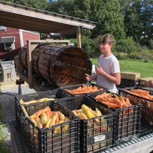 2021 Summer Teen Ag Crew Leader, Cole Thompson, operating the rootwasher at Erickson Fields. (Photo courtesy Maine Coast Heritage Trust)