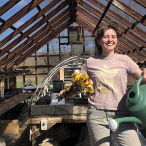 Kathleen Williams, MOFGA Farm Apprentice standing in the greenhouse at Erickson Fields Preserve. (Photo courtesy Aaron Englander)