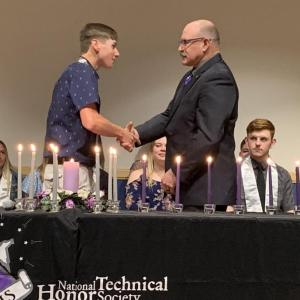 Electrical Trades Instructor Dan Schaeffer congratulates his student, NTHS inductee Kyle Payson from Belfast Area High School. (Photo courtesy Waldo County Technical Center )