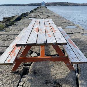 A picnic table appeared out the Rockland Breakwater May 7, stumping regular walkers as to who hauled it out there. (Photo by Renee Heal)